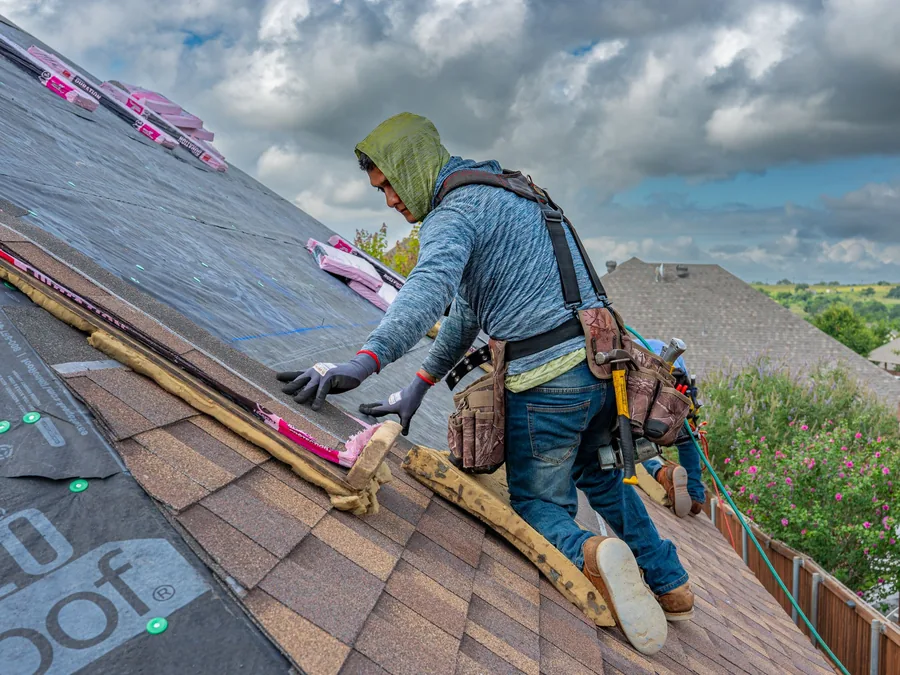Roofer fastening new asphalt shingles