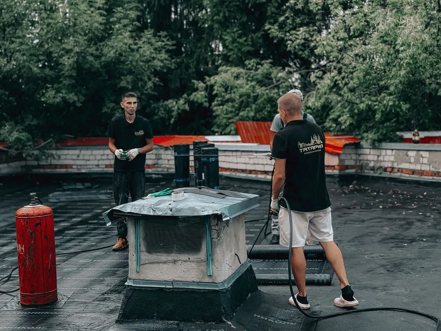 Roofers maintaining a commercial flat roof