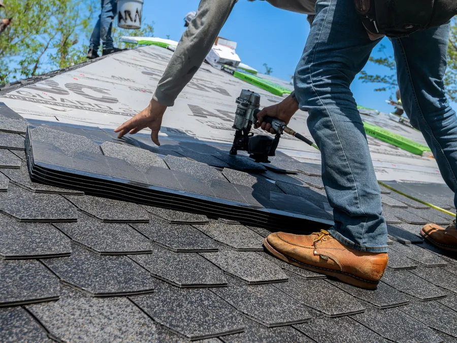 Roofer installing shingles on a pitched roof