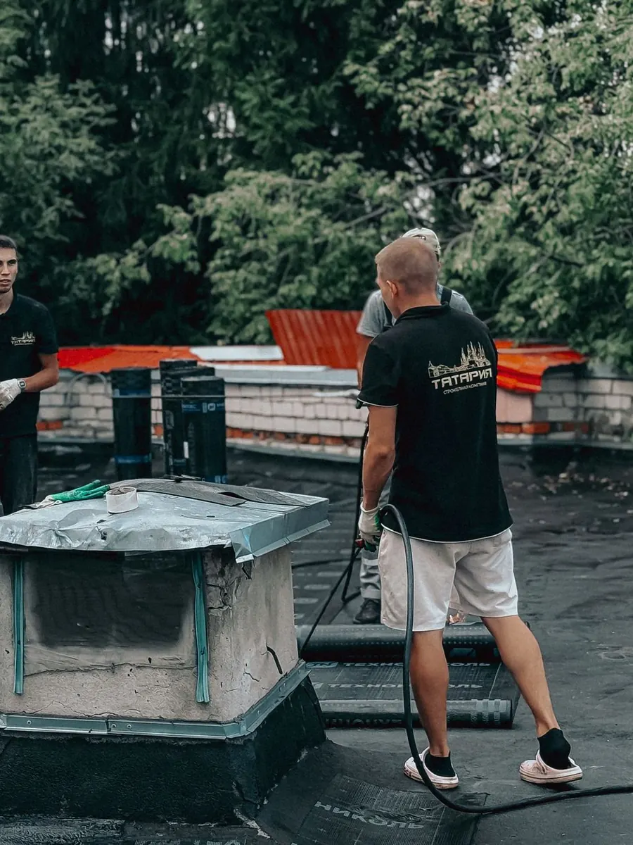 Roofers maintaining a commercial flat roof