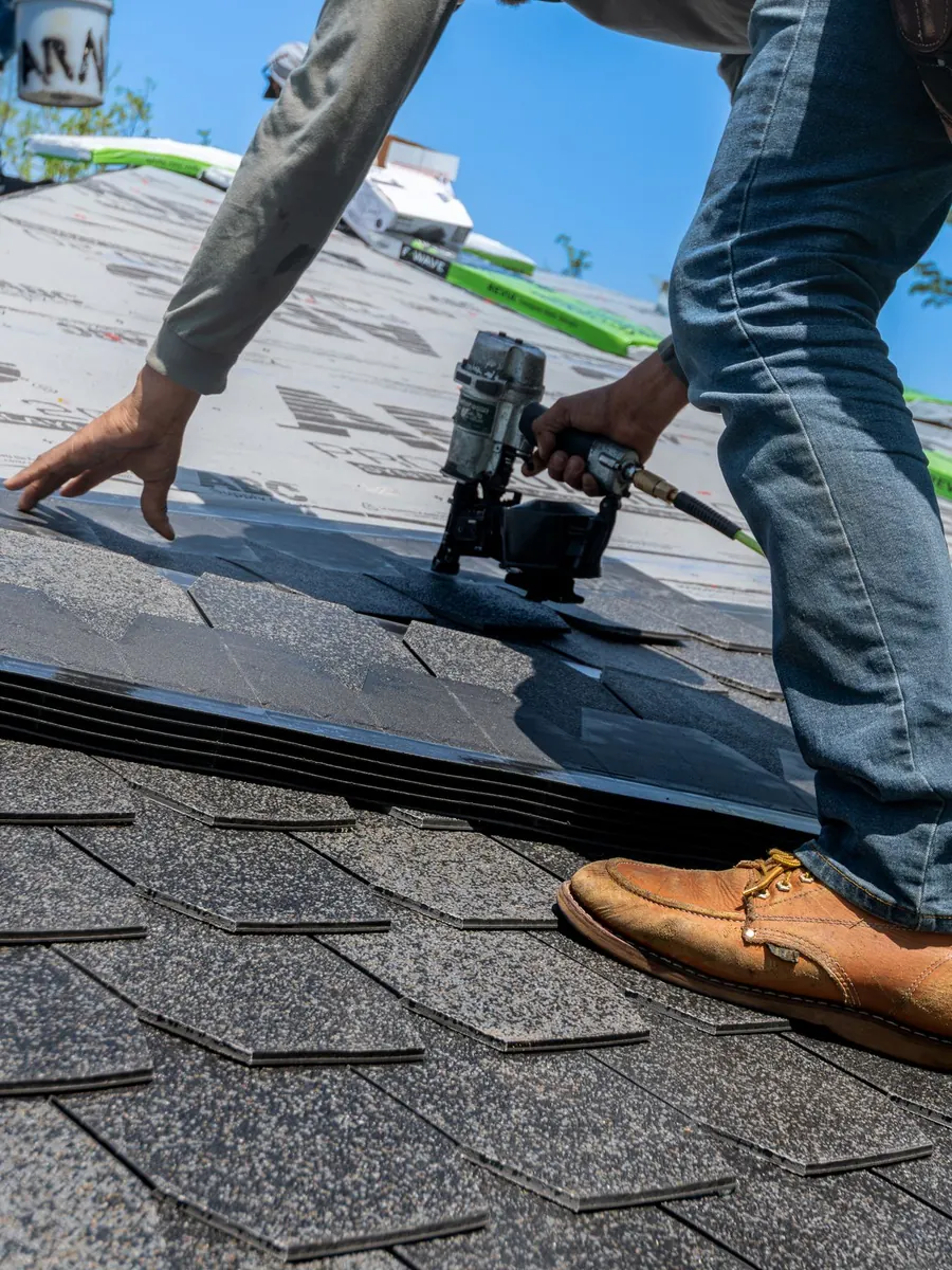 Roofer installing shingles